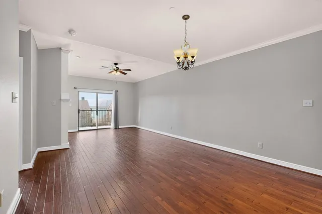 a view of empty room with wooden floor and window
