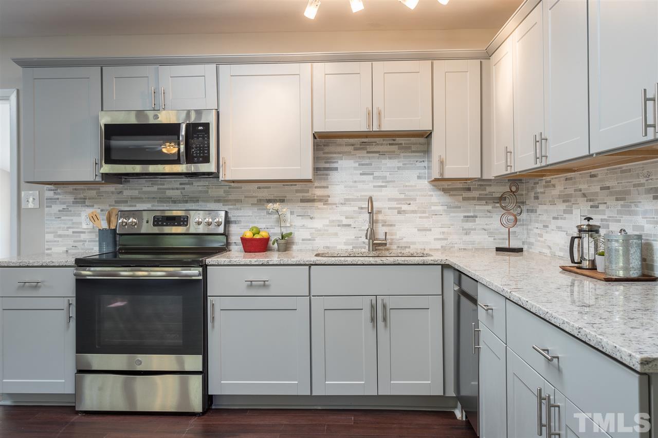 4907 Brentwood Road Durham, NC 27713 - Photo 11 of 27 a kitchen with granite countertop white cabinets and stainless steel appliances