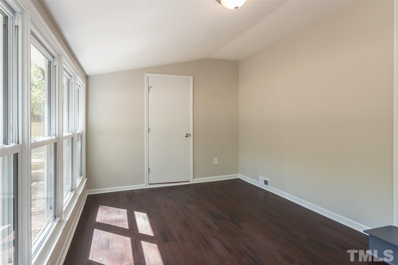 4907 Brentwood Road Durham, NC 27713 - Photo 14 of 27 a view of an empty room with wooden floor and a window