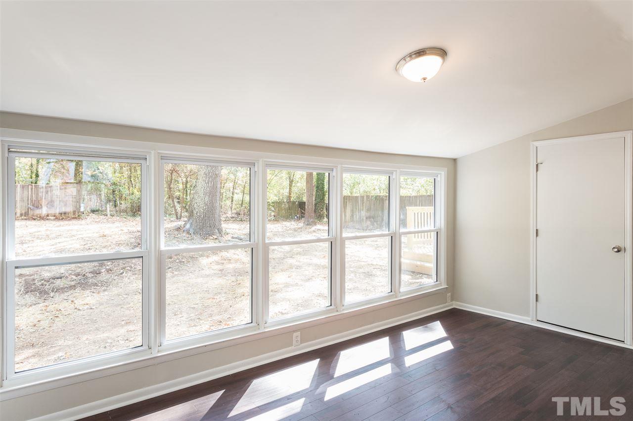 4907 Brentwood Road Durham, NC 27713 - Photo 16 of 27 a view of an empty room with wooden floor and a window