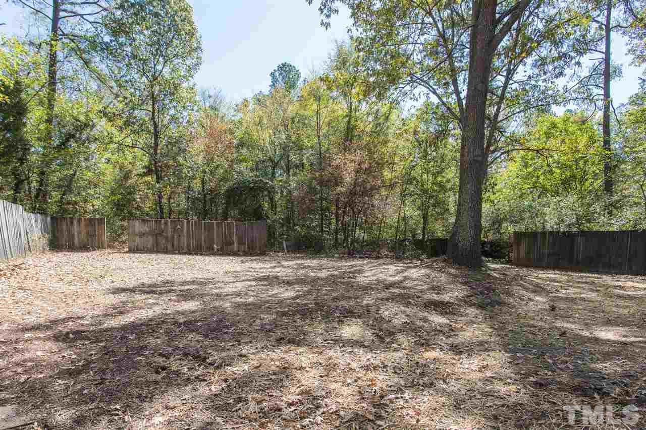 4907 Brentwood Road Durham, NC 27713 - Photo 27 of 27 a backyard of a house with large trees and wooden fence