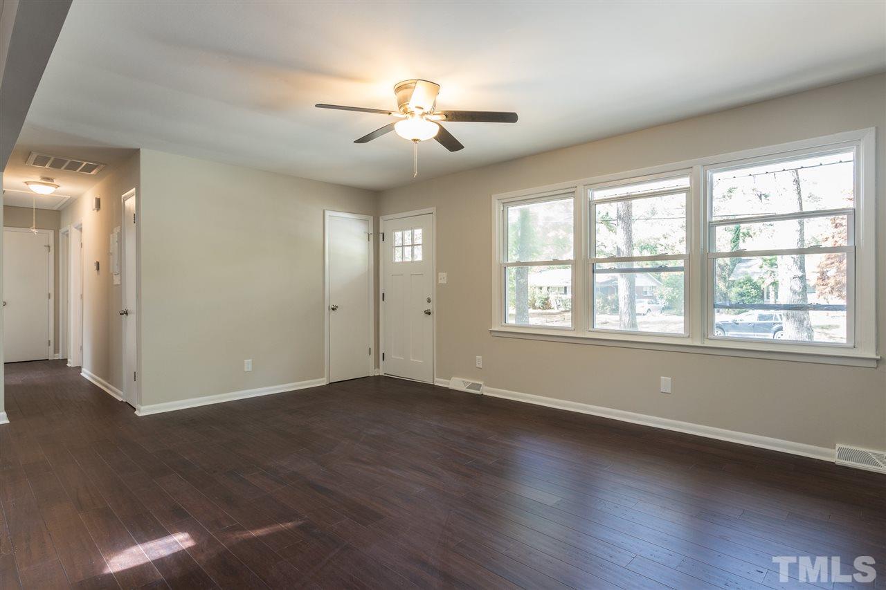 4907 Brentwood Road Durham, NC 27713 - Photo 5 of 27 a view of an empty room with wooden floor and a window