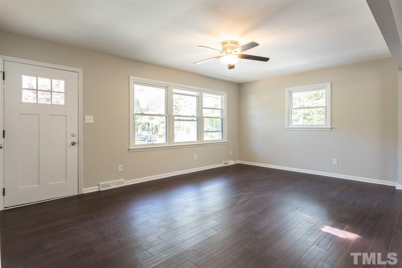 4907 Brentwood Road Durham, NC 27713 - Photo 6 of 27 a view of an empty room with wooden floor and a window