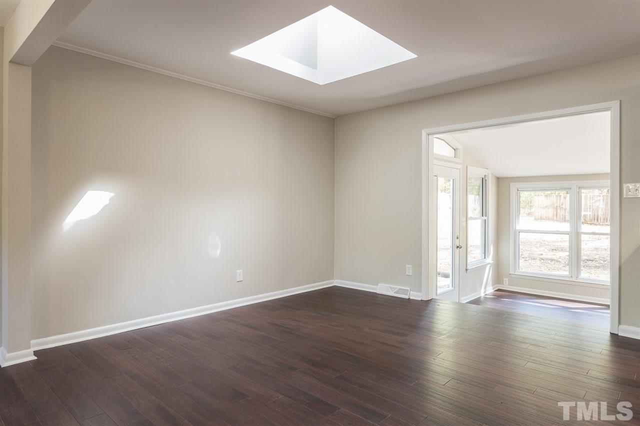 4907 Brentwood Road Durham, NC 27713 - Photo 7 of 27 a view of an empty room with wooden floor and a window