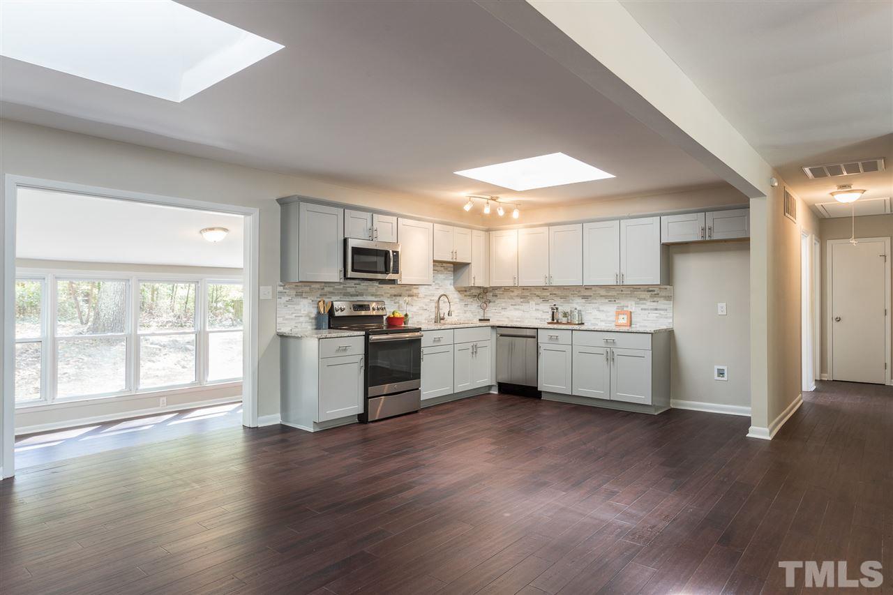 4907 Brentwood Road Durham, NC 27713 - Photo 8 of 27 a kitchen with a white cabinets and wooden floor
