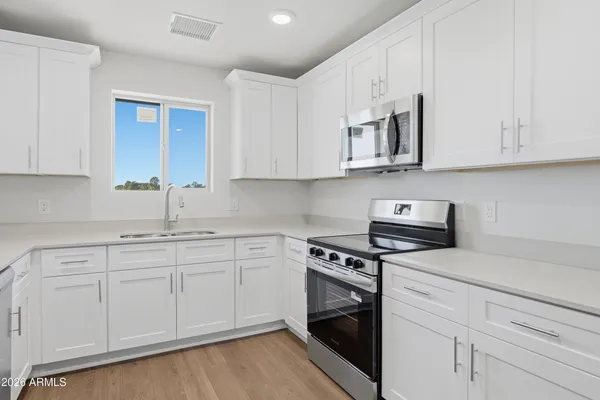 a kitchen with white cabinets and stainless steel appliances