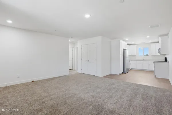 a view of an empty room with a kitchen