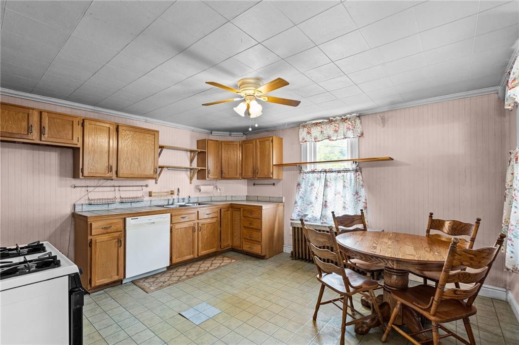 422 Mifflin Road Pittsburgh, PA 15207 - Photo 4 of 18 a kitchen with a stove a sink dishwasher a dining table and chairs with wooden floor