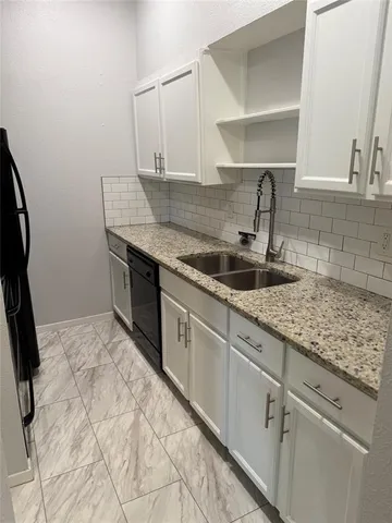 a kitchen with stainless steel appliances granite countertop a sink and cabinets