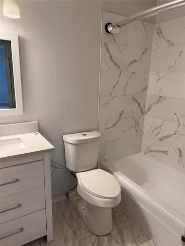 a white toilet sitting next to a bath tub and a shower