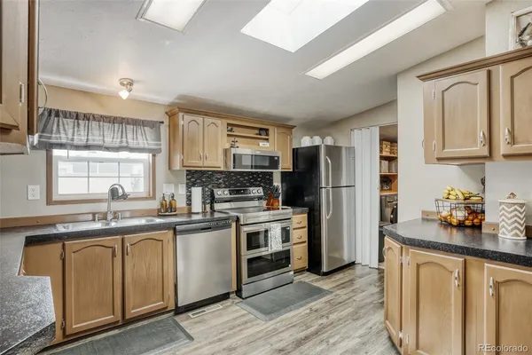 a kitchen with stainless steel appliances granite countertop a refrigerator and a stove top oven