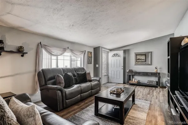 a living room with furniture a flat screen tv and a window