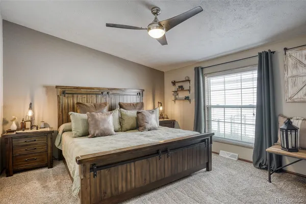 a bedroom with a bed a dresser and a chandelier