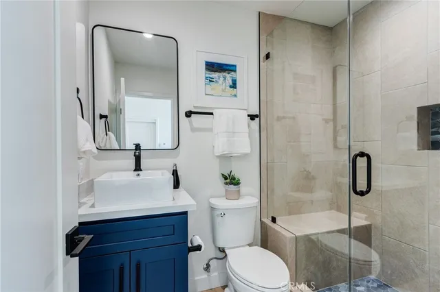 a bathroom with a granite countertop sink a toilet and mirror