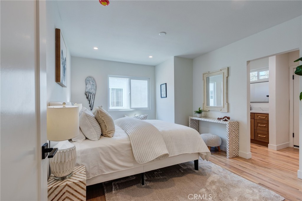 11919 Mayfield Avenue, Unit 2 Los Angeles, CA 90049 - Photo 29 of 75 a bedroom with a large bed and a chandelier