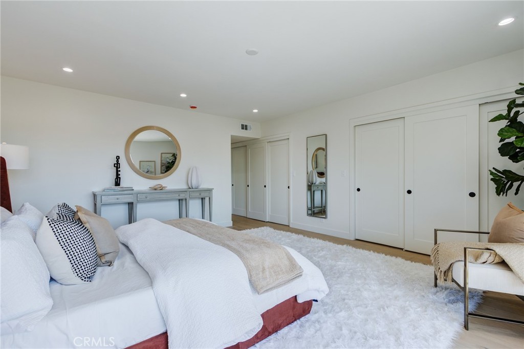 11919 Mayfield Avenue, Unit 2 Los Angeles, CA 90049 - Photo 49 of 75 a bedroom with a bed a mirror and lamp