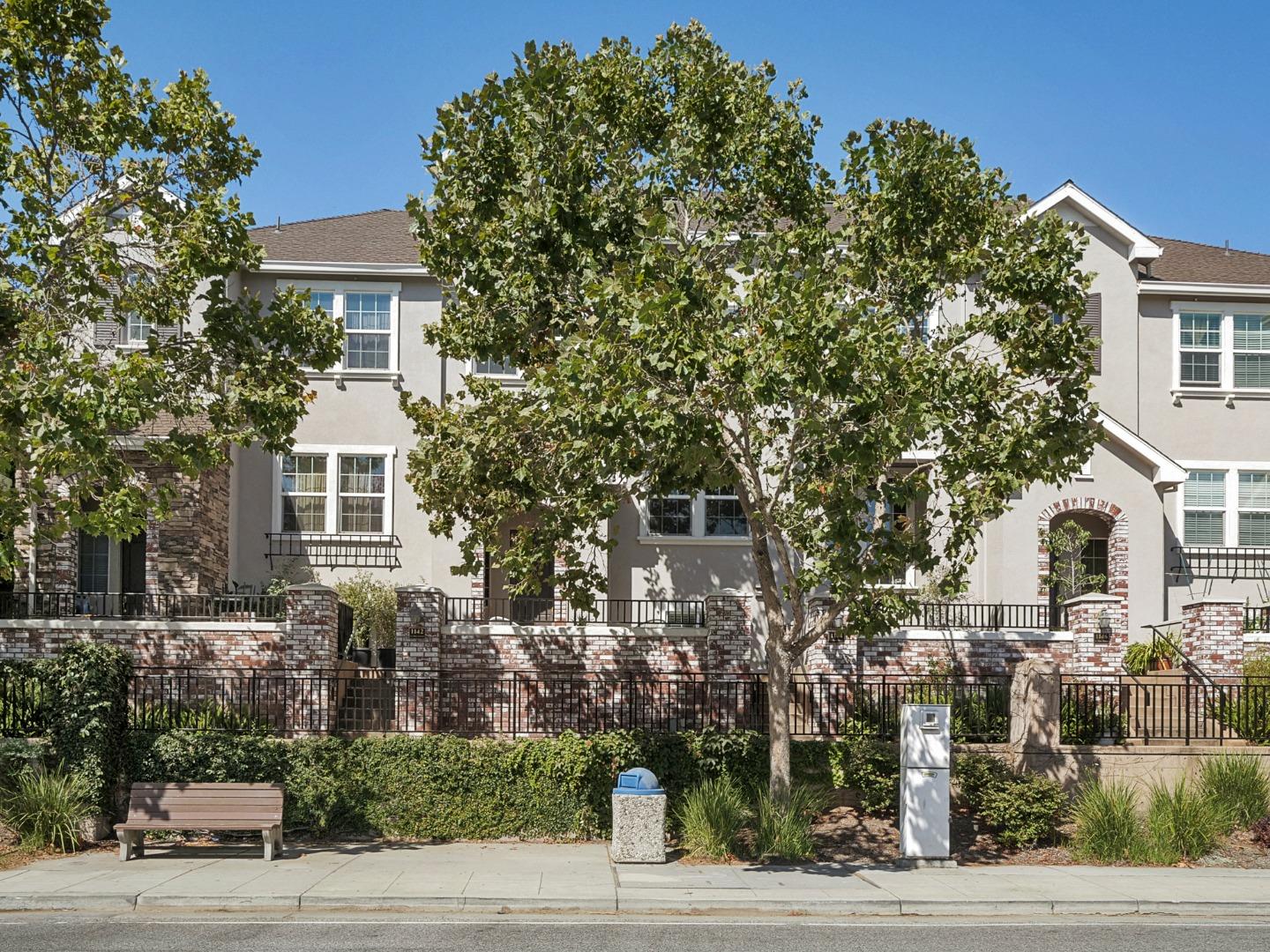 a front view of a house with a tree