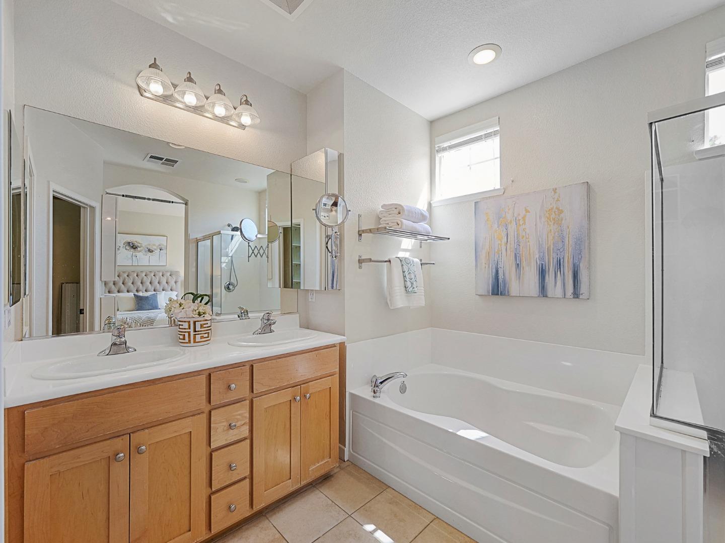 1144 Le Mans Terrace Sunnyvale, CA 94089 - Photo 19 of 29 a bathroom with a tub a double vanity sink and a mirror