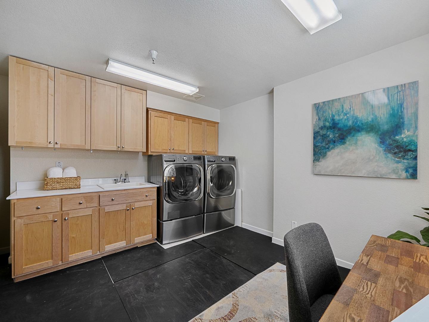 1144 Le Mans Terrace Sunnyvale, CA 94089 - Photo 24 of 29 a kitchen with stainless steel appliances kitchen island granite countertop a refrigerator a stove a sink and white cabinets with wooden floor