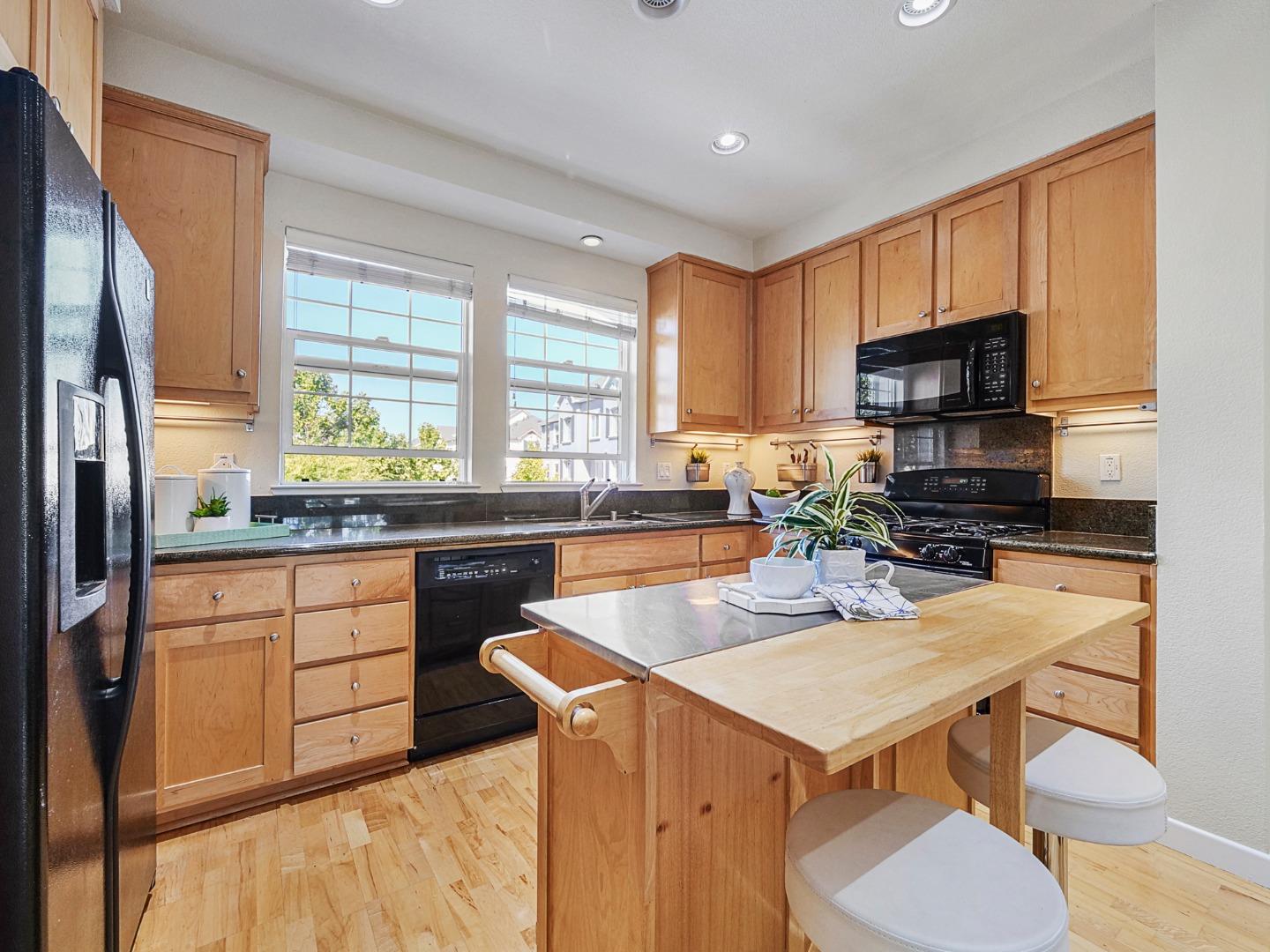 1144 Le Mans Terrace Sunnyvale, CA 94089 - Photo 5 of 29 a kitchen with a refrigerator a stove a sink dishwasher with a dining table and chairs