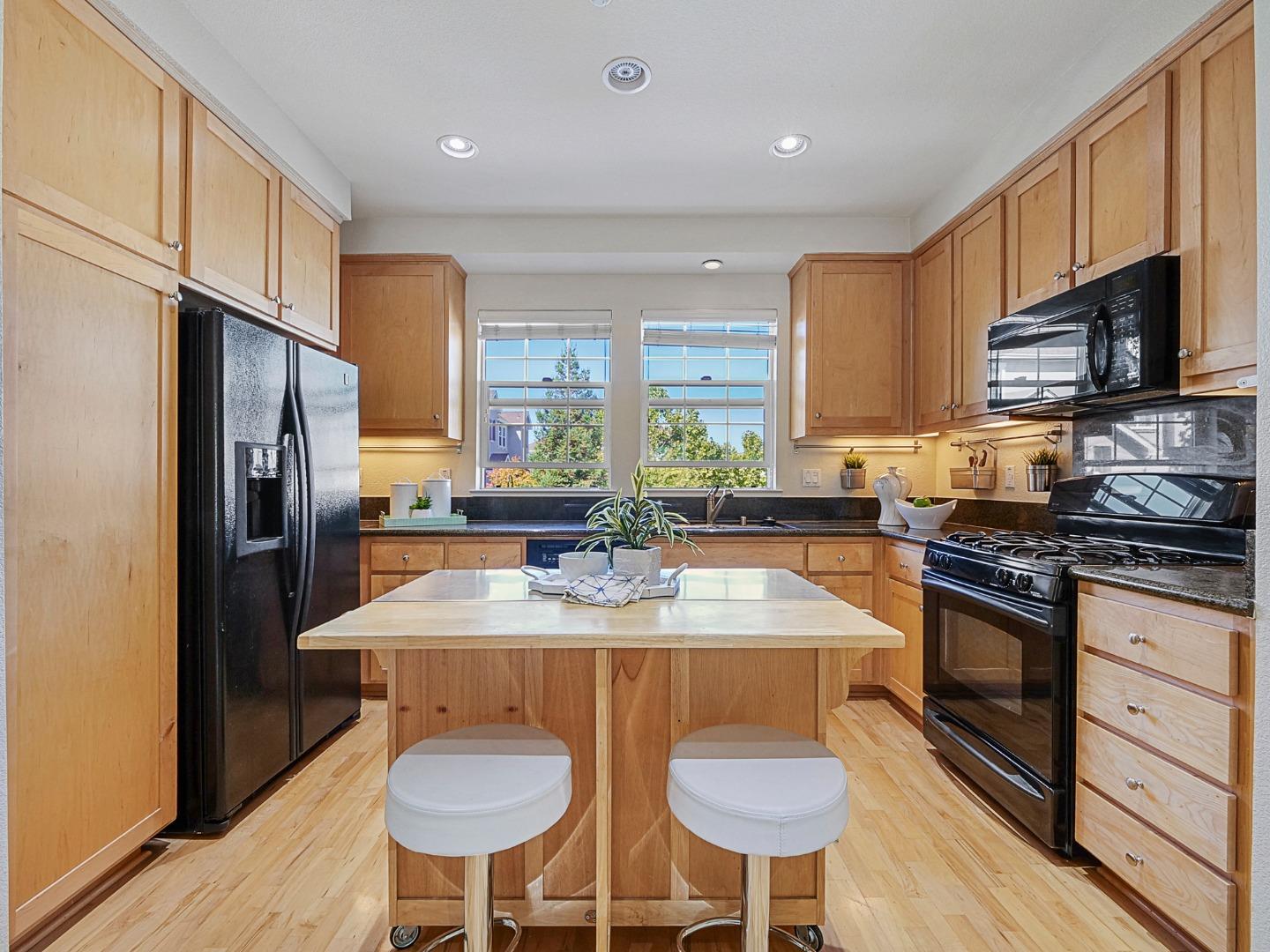 1144 Le Mans Terrace Sunnyvale, CA 94089 - Photo 6 of 29 a kitchen with stainless steel appliances granite countertop a sink a stove a refrigerator cabinets and a dining table
