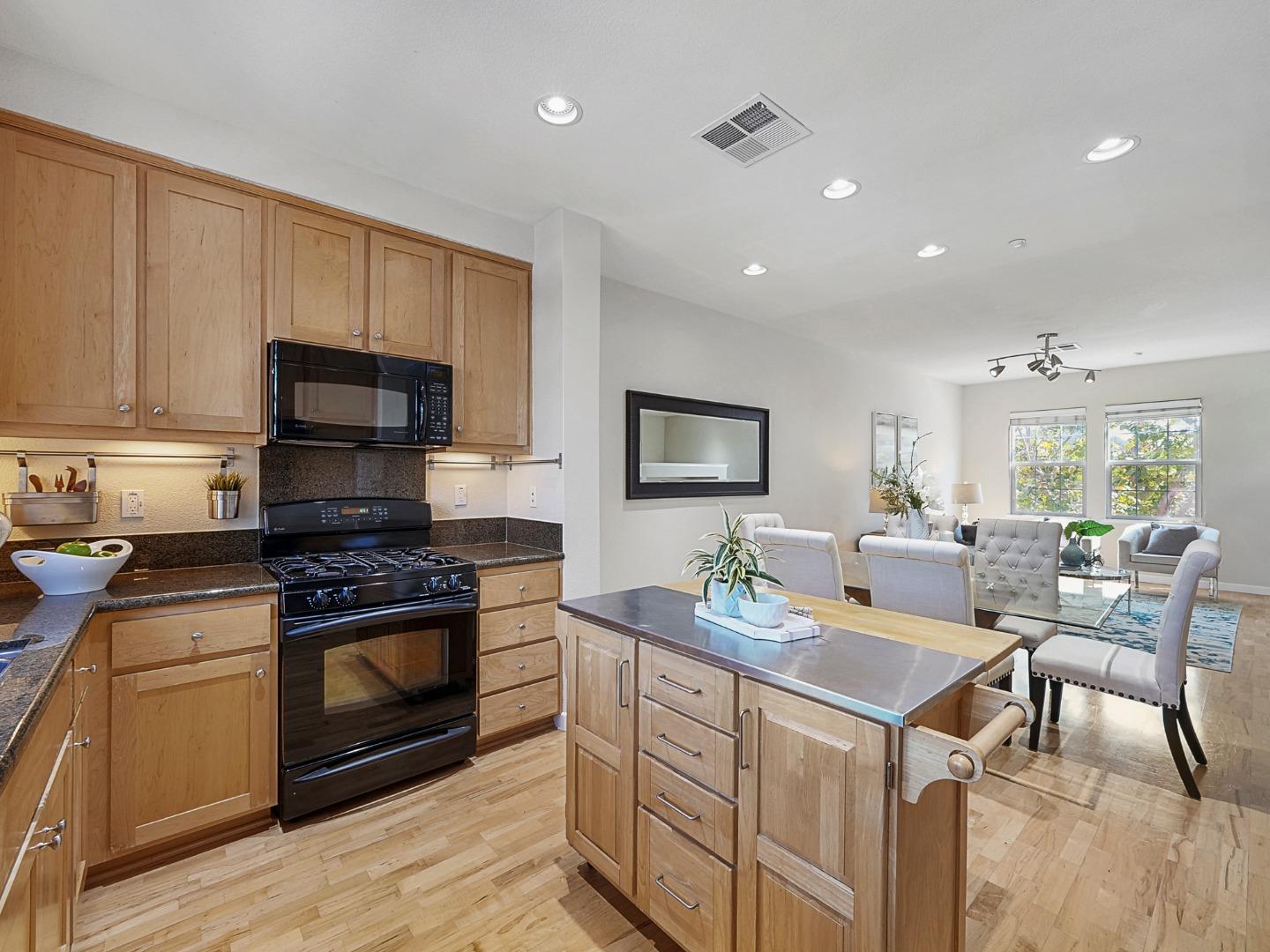 1144 Le Mans Terrace Sunnyvale, CA 94089 - Photo 7 of 29 a kitchen with sink stove microwave and cabinets