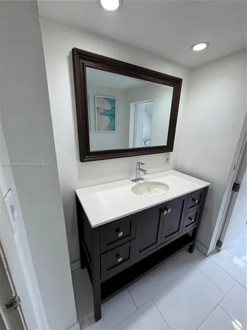 a bathroom with a sink vanity and mirror