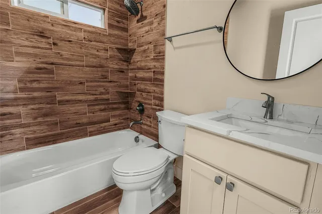 a bathroom with a granite countertop toilet sink and mirror