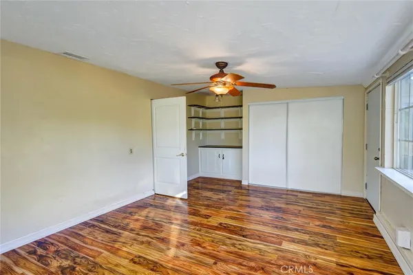a view of empty room with wooden floor