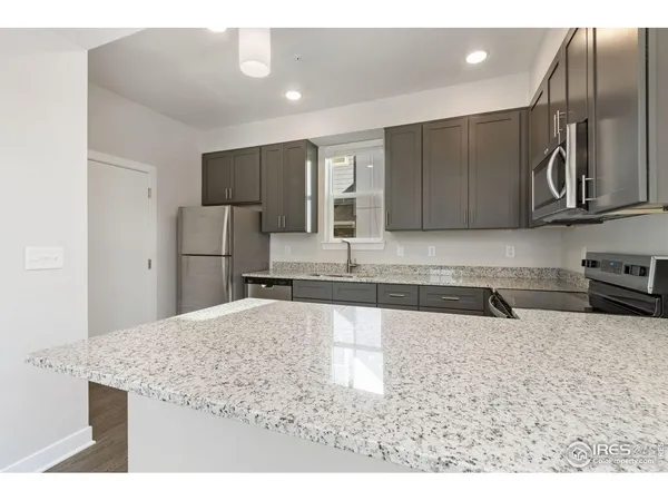 a kitchen with stainless steel appliances granite countertop a sink refrigerator and microwave