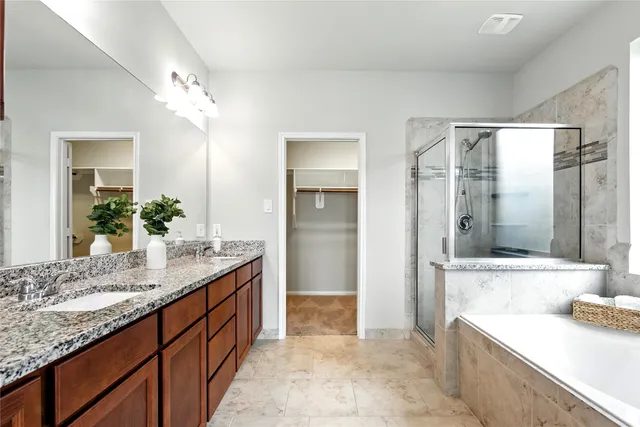 a spacious bathroom with a granite countertop sink mirror and shower