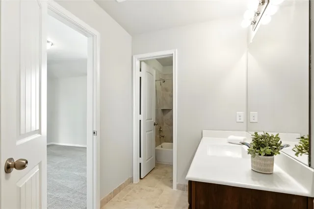a bath tub sitting next to a white sink and a toilet