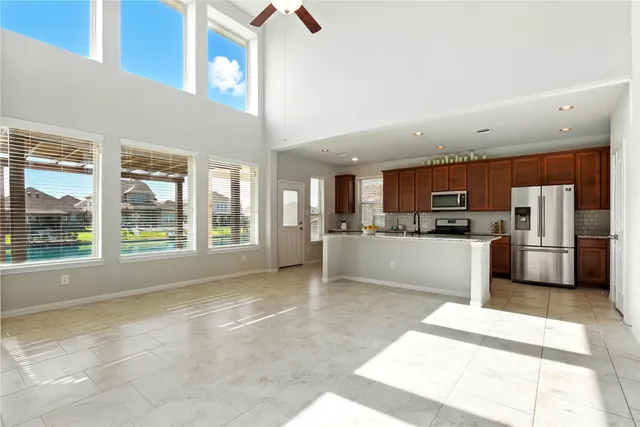 a open kitchen with stainless steel appliances kitchen island granite countertop a refrigerator and cabinets