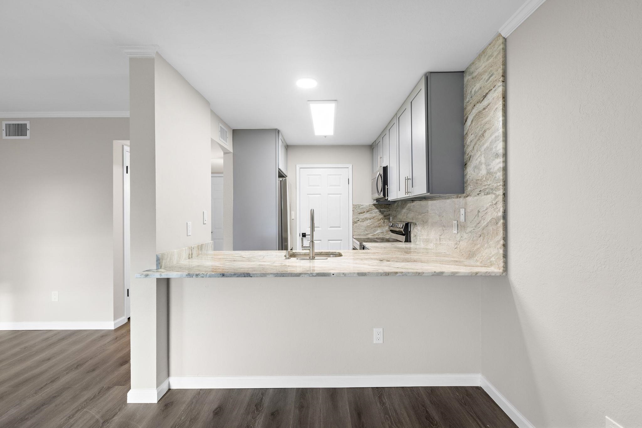 690 Route 23 Wayne Nj 07470, Unit R3 Wayne, NJ 07470 - Photo 6 of 13 a view of a kitchen with kitchen island a sink wooden floor and black appliances