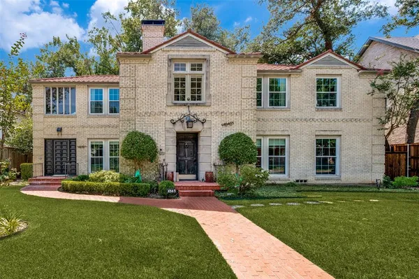 a front view of a house with a yard and potted plants