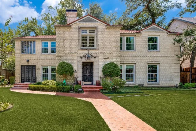 a front view of a house with a yard and potted plants