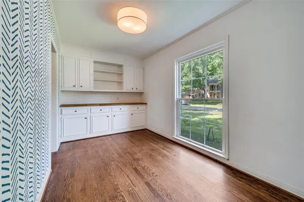 a view of a kitchen with wooden floor and a window