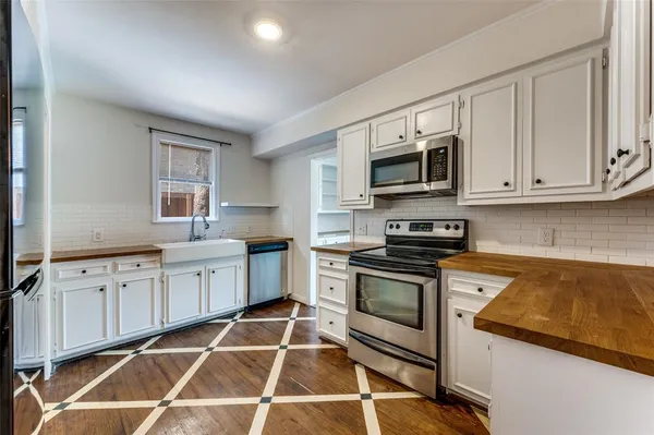 a kitchen with granite countertop a stove and white cabinets