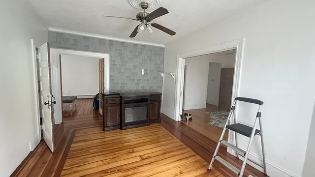 a view of a hallway with wooden floor and staircase