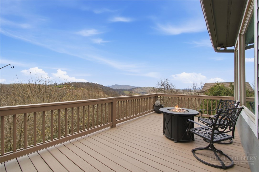 880 Algonquin Drive Boone, NC 28607 - Photo 12 of 50 a view of a balcony with wooden floor chairs and iron fence