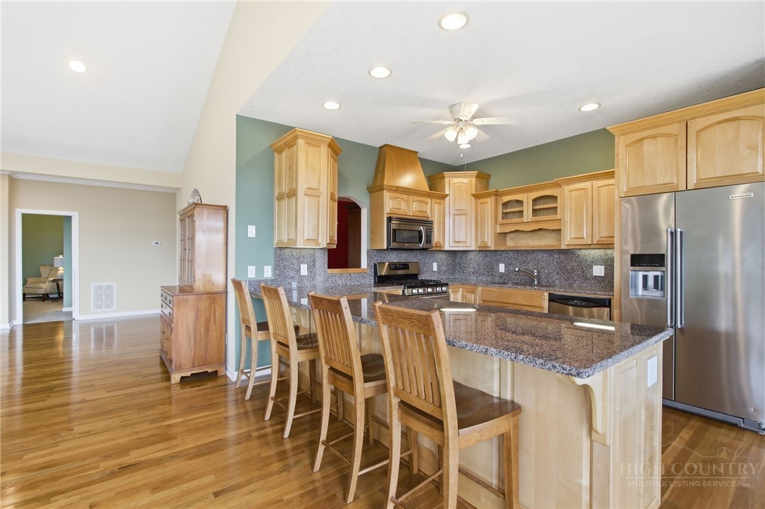 880 Algonquin Drive Boone, NC 28607 - Photo 24 of 50 a kitchen with stainless steel appliances granite countertop a refrigerator a stove top oven and a island with wooden floor
