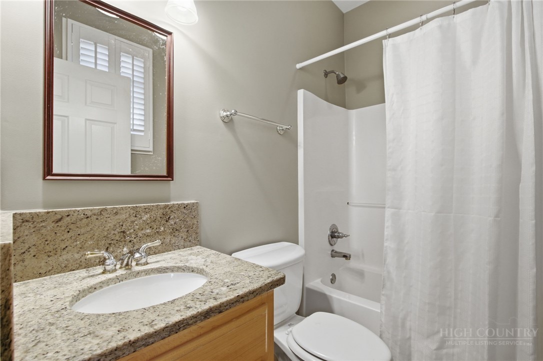 880 Algonquin Drive Boone, NC 28607 - Photo 46 of 50 a bathroom with a granite countertop sink toilet a mirror and a shower