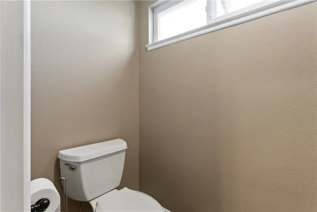 a white toilet sitting next to a window
