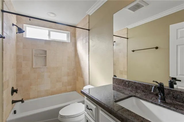 a bathroom with a granite countertop sink toilet and shower