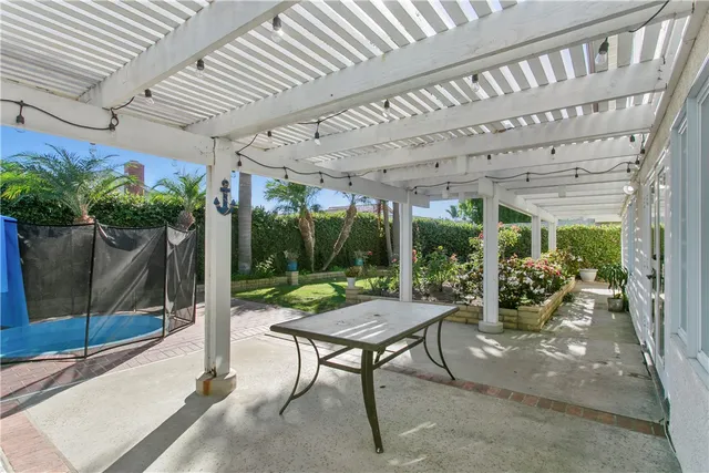 a view of a patio with table and chairs potted plants and palm tree