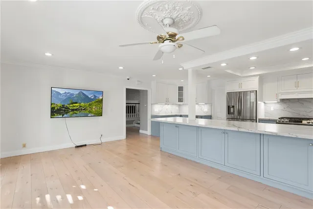 a view of kitchen with stainless steel appliances refrigerator stove microwave and cabinets