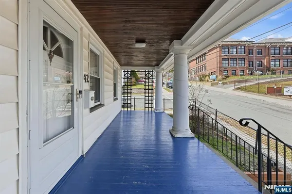 a view of a hallway with wooden floor a living room and bathroom