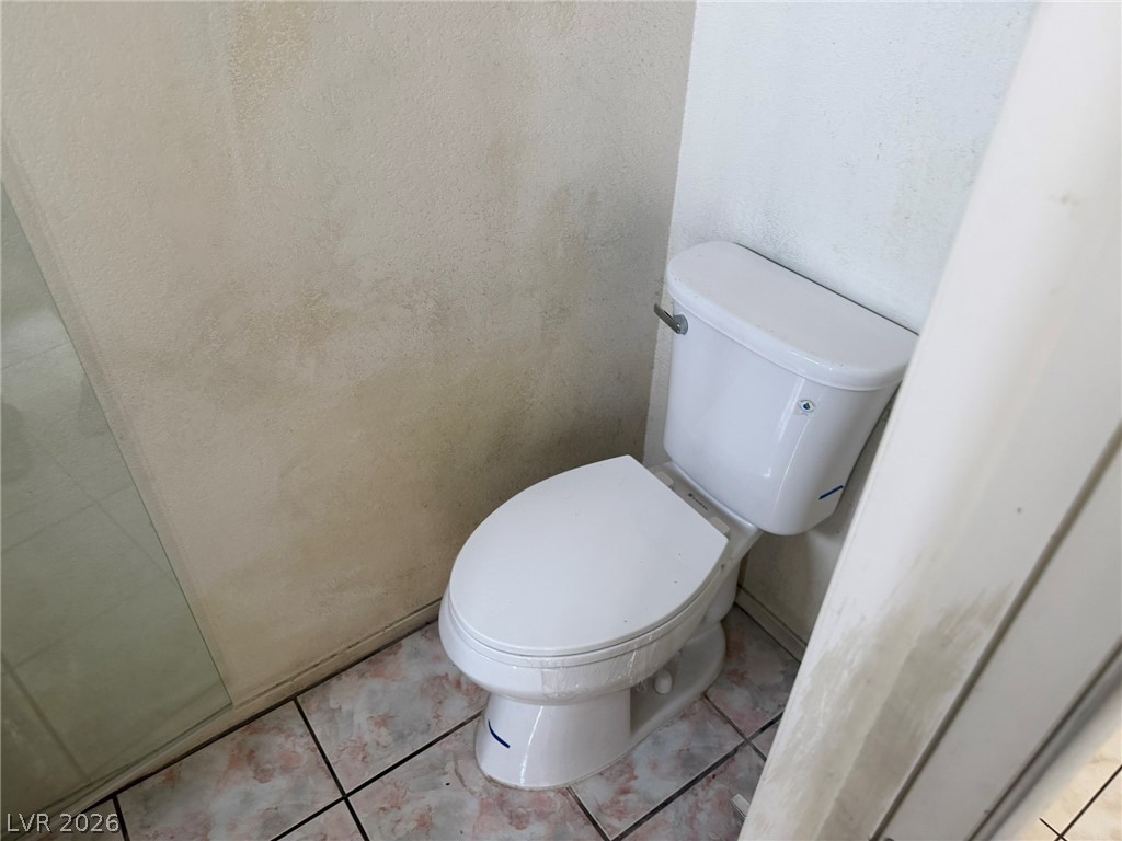 277 Gentle Bay Avenue Henderson, NV 89074 - Photo 28 of 43 This functional bathroom features a toilet and tiled flooring, offering practicality.