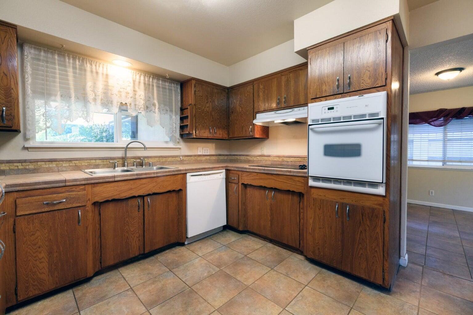 6781 Reflection Street Redding, CA 96001 - Photo 4 of 13 a kitchen with stainless steel appliances granite countertop a sink stove and refrigerator