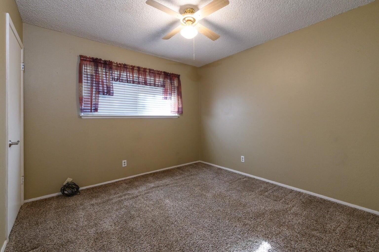 6781 Reflection Street Redding, CA 96001 - Photo 8 of 13 an empty room with a window and a ceiling fan